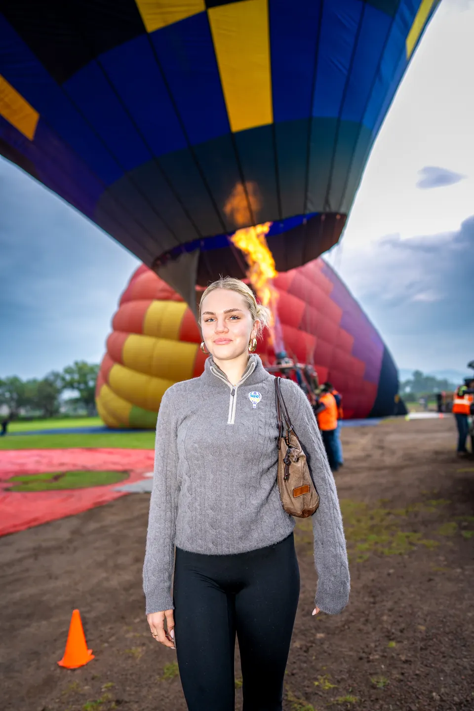Private balloon flight over Teotihuacan: young woman smiling as the crew inflates the balloon with the burner lit
