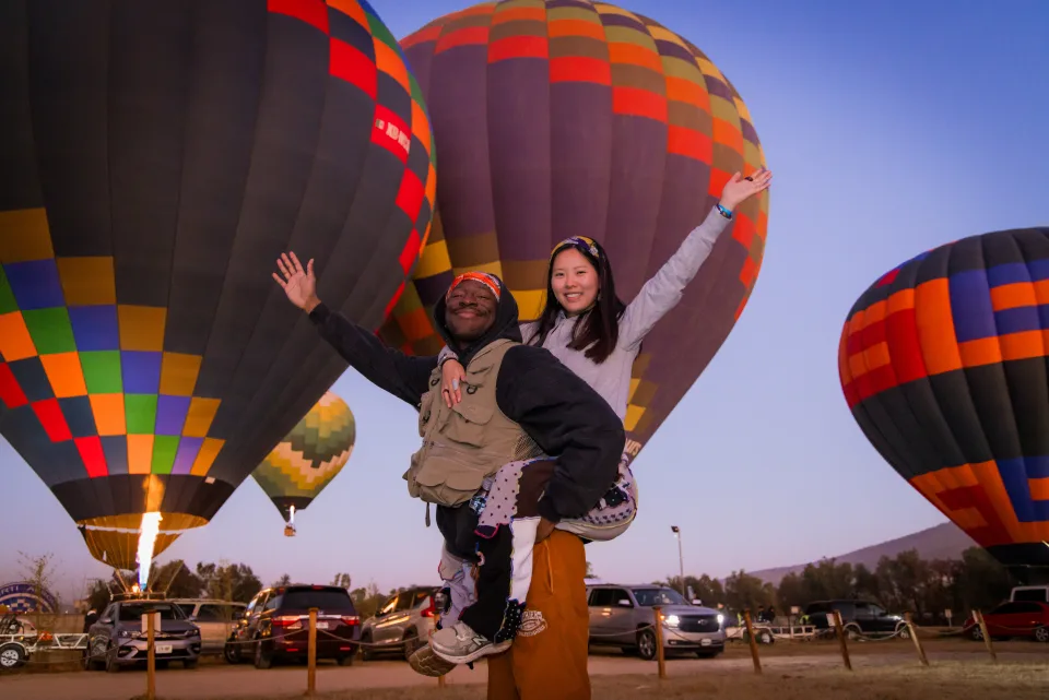 Pareja a caballito con globos alrededor al amanecer