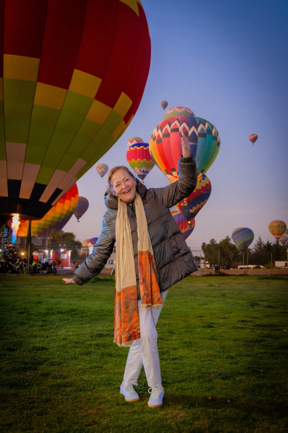 Viajera mayor alegre posando con muchos globos al amanecer — vuelos para todas las edades