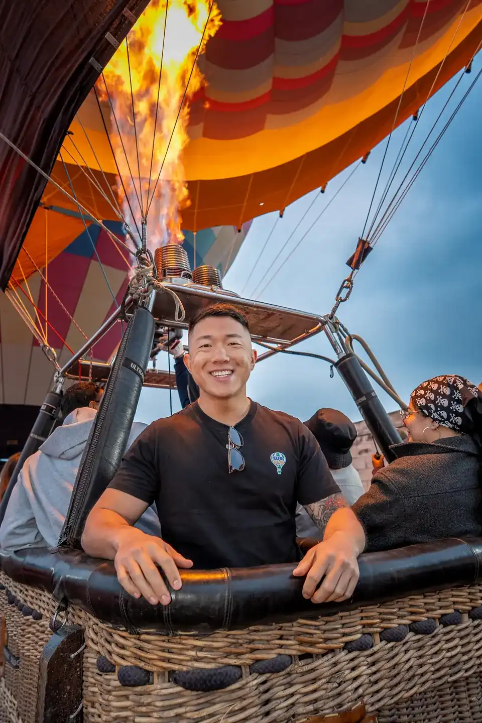 All inclusive shared flight with transportation from Mexico City: smiling passenger in the basket while the burner inflates the envelope