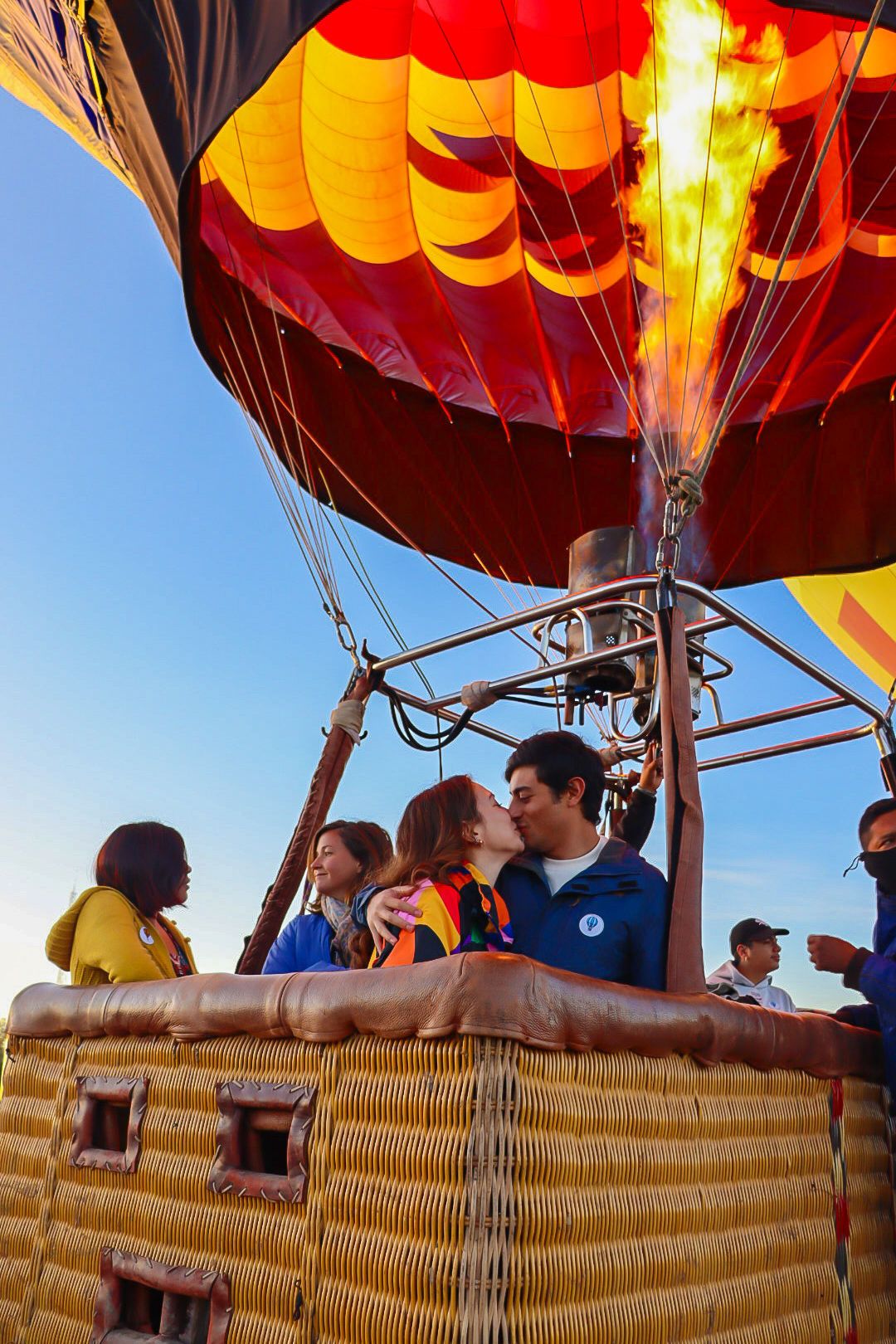 Globo aerostático rojo con pasajeros volando sobre Teotihuacán