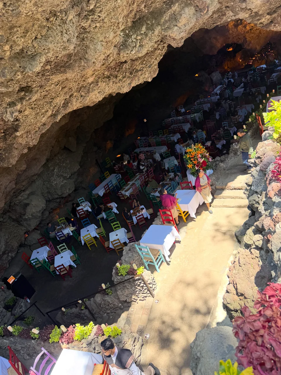 The dining hall of La Gruta seen from above, tables scattered across the floor of the grotto