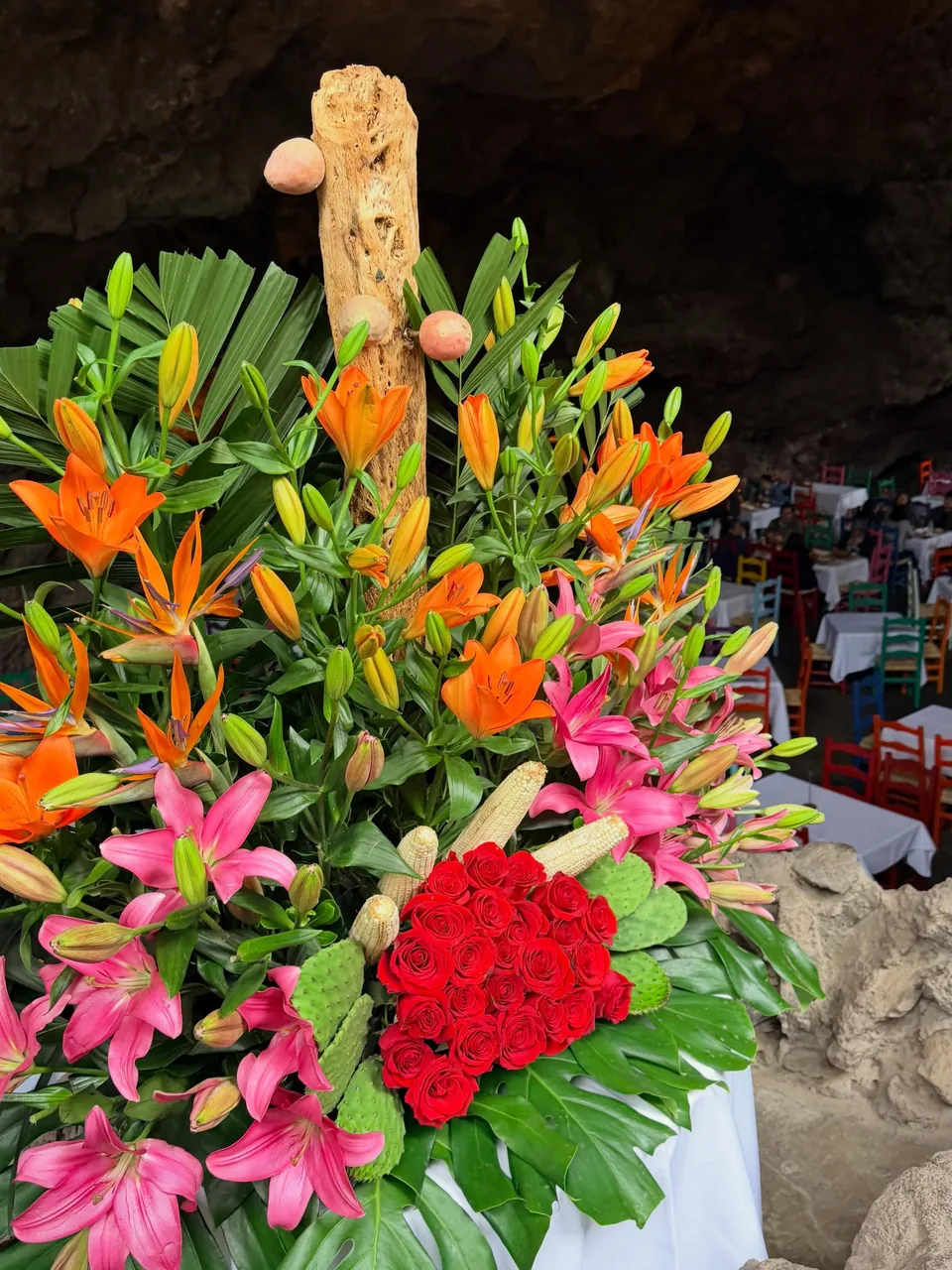 A tall flower arrangement on a table at La Gruta Teotihuacan
