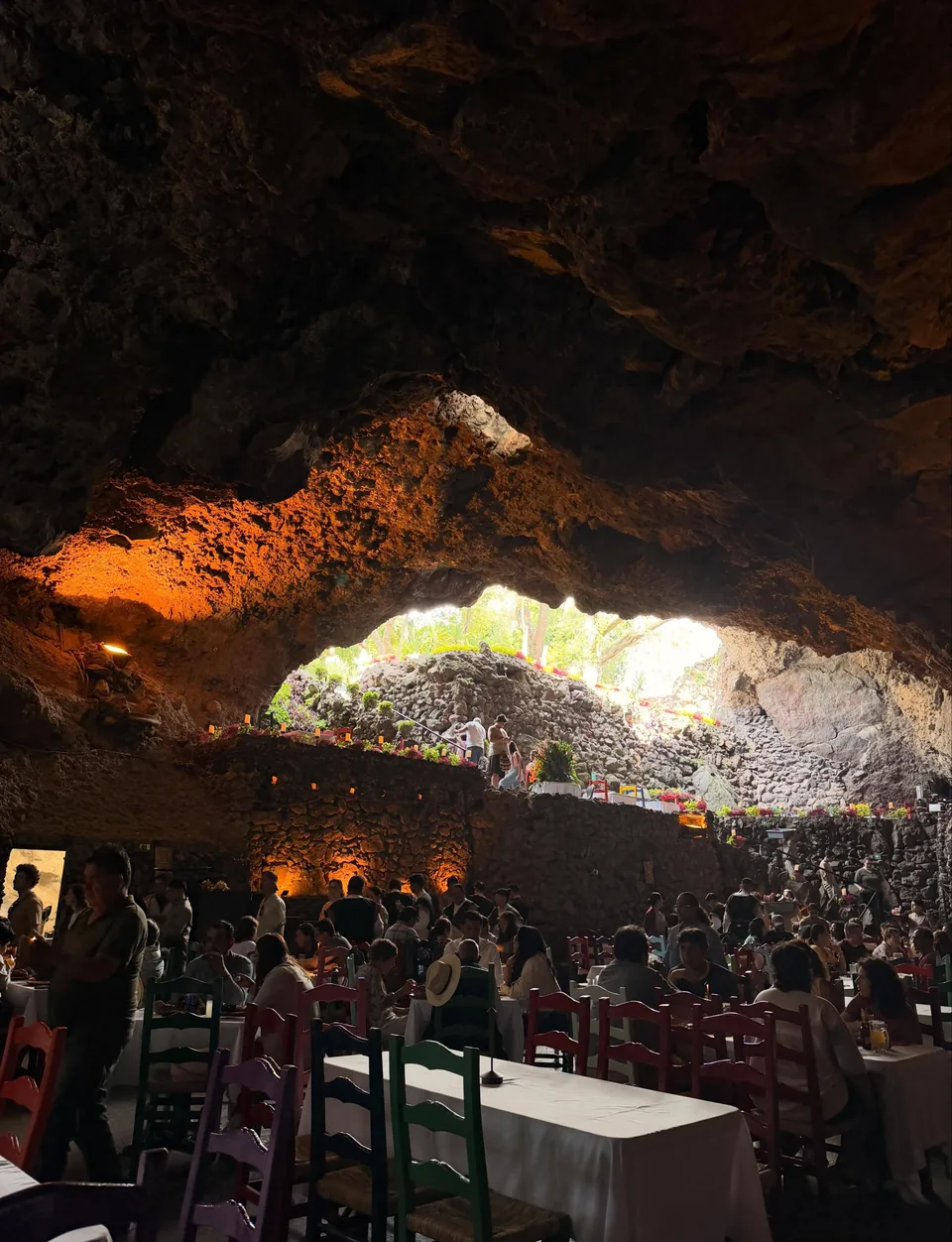 A full dining room under the great rock arch at La Gruta Teotihuacan