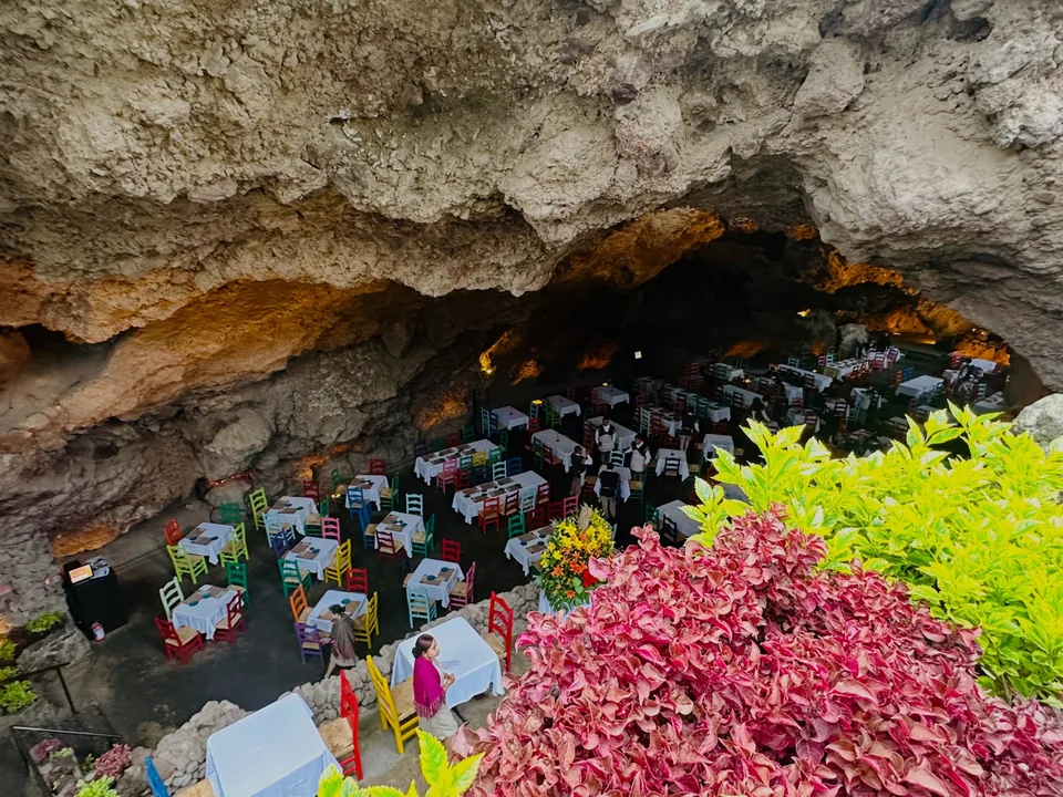The mouth of La Gruta in Teotihuacan framed by bougainvillea and greenery