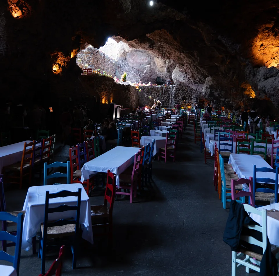 A long aisle of set tables running through the grotto at La Gruta Teotihuacan