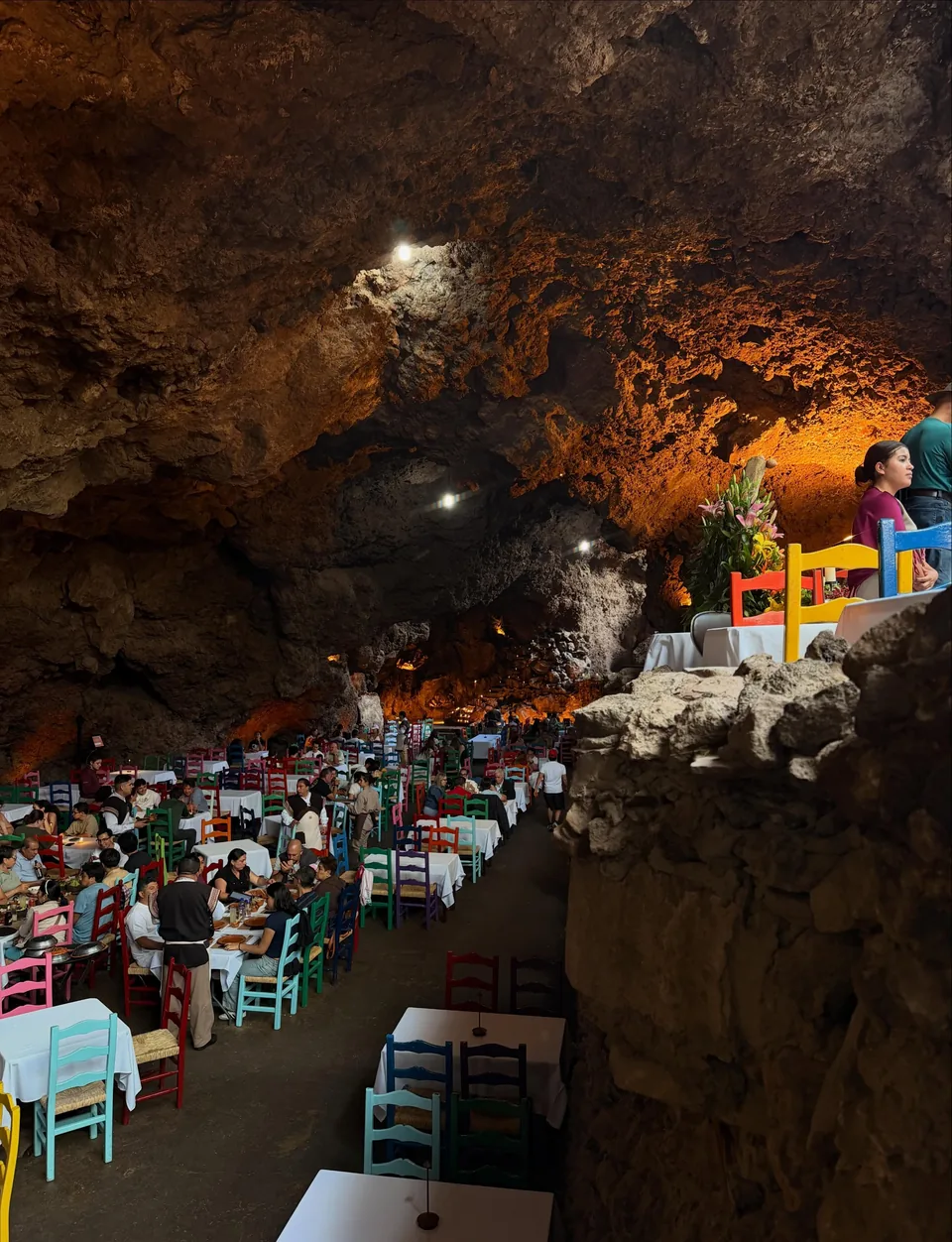 Side view of the grotto dining hall at La Gruta, lit by warm lamps