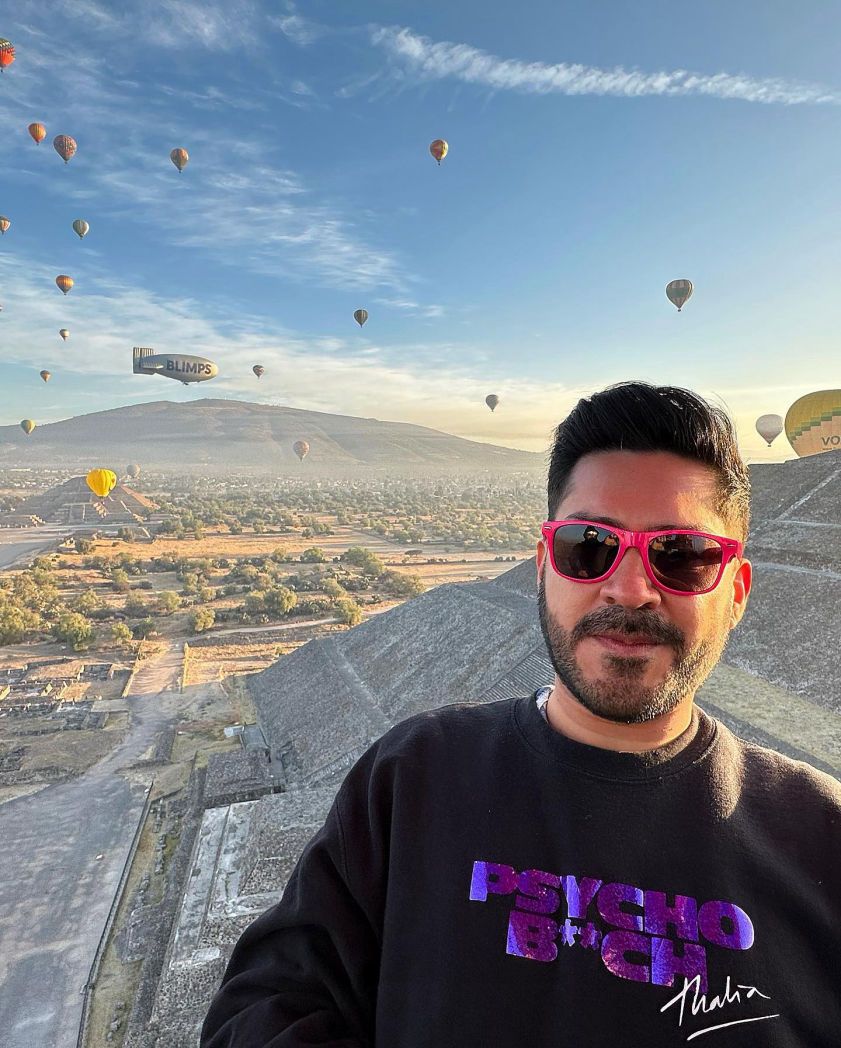 Selfie de pasajeras con globos aerostáticos al fondo en Teotihuacán